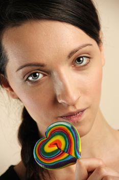 Girl licking a coloful lollipop.