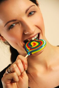 Girl licking a coloful lollipop.