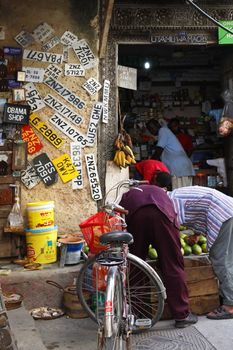 Stone town, Tanzania - December 30, 2015: Stone Town. Streets of the town are always lively. There are many shops, restaurants and bars, where tourists can relax and buy suvenirs. Here is a man apparently collecting old number plates.