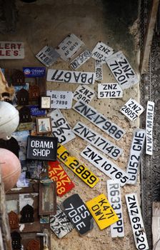 Stone town, Tanzania - December 30, 2015: Stone Town. Streets of the town are always lively. There are many shops, restaurants and bars, where tourists can relax and buy suvenirs. Here is a man apparently collecting old number plates.