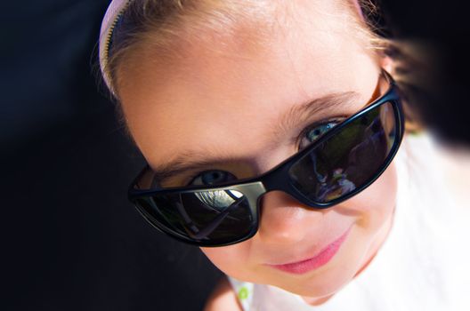 Little Caucasian Girl in Sunglasses Portrait. Summer Time Concept.