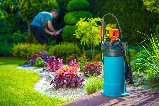 Garden Pest Control Spray and Male Gardener in the Background. Spraying Pesticides in a Garden. Gardening Theme.
