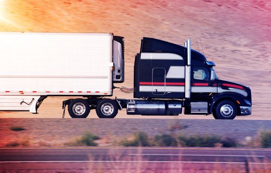 Speeding Semi Truck on a Highway. Heavy Duty Road Transportation Concept.