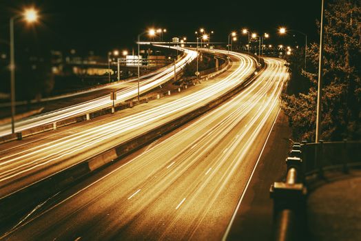 American Highways System at Night. Traffic in Motion. Long Exposure Photo. Dark Sepia Color Grading.