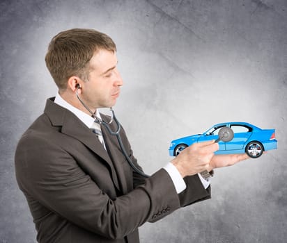 Businessman with stethoscope hearing car on his hand