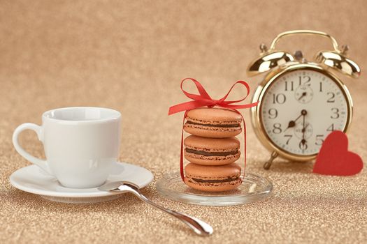 Macarons french dessert, cup of coffee.Gold alarm clock, breakfast time, red heart.Vintage retro romantic style.Unusual creative art greeting card, shiny background. Love,Valentines Day