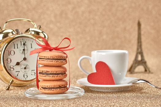 Macarons french dessert, cup of coffee.Gold alarm clock, breakfast time. Eiffel Tower, souvenir Paris, red heart.Vintage retro romantic style.Unusual creative art greeting card, shiny background,bokeh