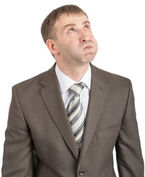 Businessman with inflated cheeks looking up isolated on white background