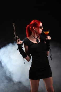 Sexy red hair woman with a gun and a cocktail