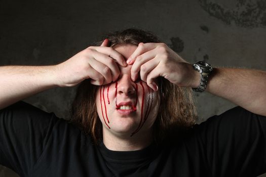 Man taking out his eyes, full of blood