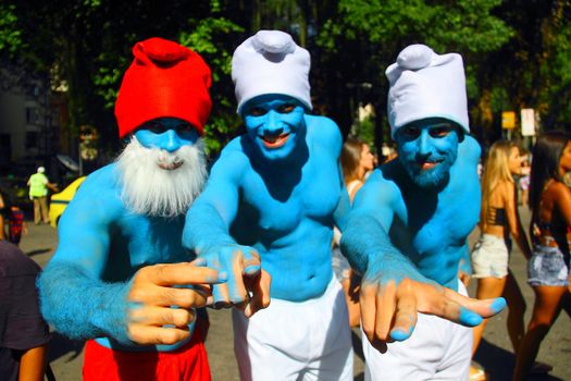 BRAZIL, Rio de Janeiro: Three men dress up as smurfs as  thousands of revelers take over the city on January 23, 2016 in a massive street party two weeks ahead of Carnival.  In the weeks leading up to the Carnival's official opening day on February 5, 2016, groups of people organize 'blocos', or street parties. Blocos are usually held in local neighbourhoods and feature brass bands and are much less formal than the parades.	 