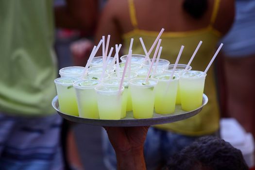BRAZIL, Rio de Janeiro: Mini margarita are served as thousands of revelers take over the city on January 23, 2016 in a massive street party two weeks ahead of Carnival.  In the weeks leading up to the Carnival's official opening day on February 5, 2016, groups of people organize 'blocos', or street parties. Blocos are usually held in local neighbourhoods and feature brass bands and are much less formal than the parades.	 