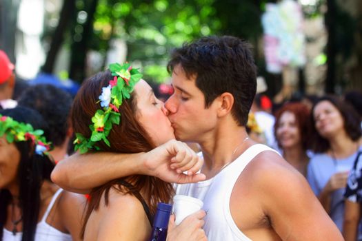 BRAZIL, Rio de Janeiro: A couple kisses as thousands of revelers take over the city on January 23, 2016 in a massive street party two weeks ahead of Carnival.  In the weeks leading up to the Carnival's official opening day on February 5, 2016, groups of people organize 'blocos', or street parties. Blocos are usually held in local neighbourhoods and feature brass bands and are much less formal than the parades.	 
