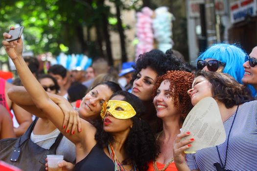 BRAZIL, Rio de Janeiro: A group of woman take a selfie as thousands of revelers take over the city on January 23, 2016 in a massive street party two weeks ahead of Carnival.  In the weeks leading up to the Carnival's official opening day on February 5, 2016, groups of people organize 'blocos', or street parties. Blocos are usually held in local neighbourhoods and feature brass bands and are much less formal than the parades.	 