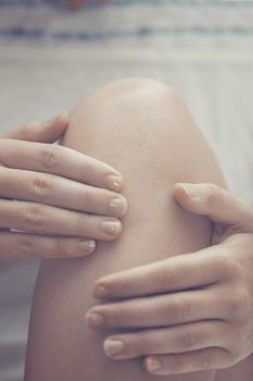 Woman doing leg massage and applying moisturizing cream