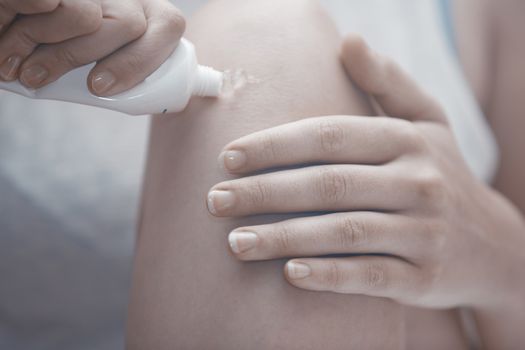 Woman doing leg massage and applying moisturizing cream