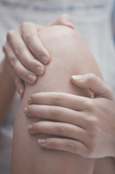 Woman doing leg massage and applying moisturizing cream