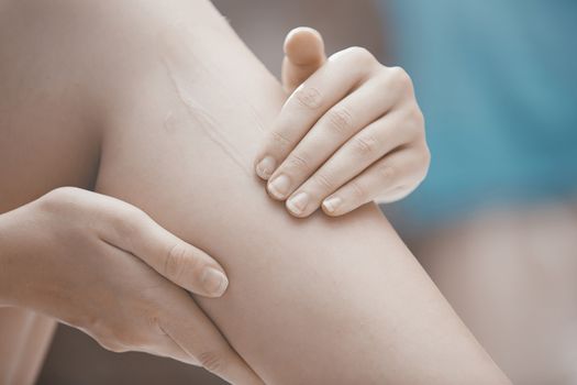 Woman doing leg massage and applying moisturizing cream