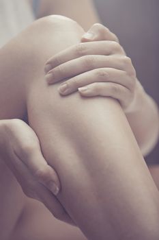 Woman doing leg massage and applying moisturizing cream