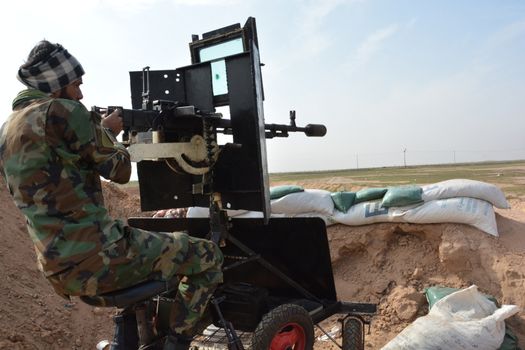 IRAQ, Al-Seneia: A PMU fighter looks through his gun sight on January 23, 2016, after the city of Al-Seneia was liberated from ISIS.The city was liberated on October 14, 2015, according to commander of Imam Ali brigade who spoke with our contributor. ISIS is said to have destroyed much of the town including important building such as schools and hospitals.