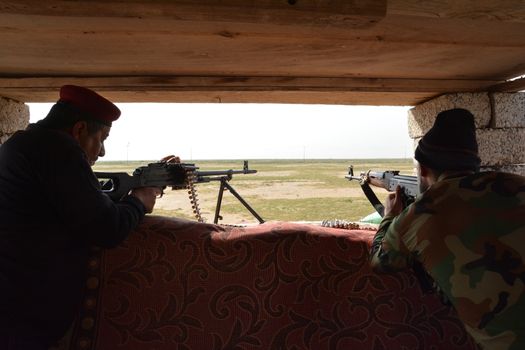 IRAQ, Al-Seneia: PMU fighters looks out from a bunker on January 23, 2016, after the city of Al-Seneia was liberated from ISIS.The city was liberated on October 14, 2015, according to commander of Imam Ali brigade who spoke with our contributor. ISIS is said to have destroyed much of the town including important building such as schools and hospitals.