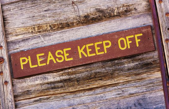 Please Keep Off Wooden Sign on the Aged Wooden Wall