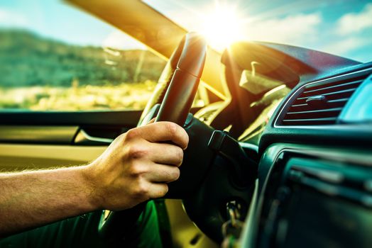 Summer Time Car Trip. Car Traveling. Men Driving Down the Road During Scenic Sunset.