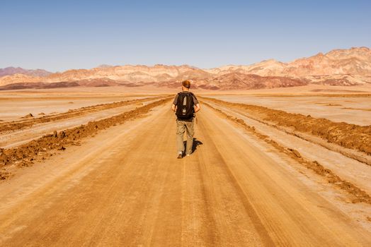 Journey To Nowhere. Tourist with Backpack Walking Through South California Desert Wilderness. 