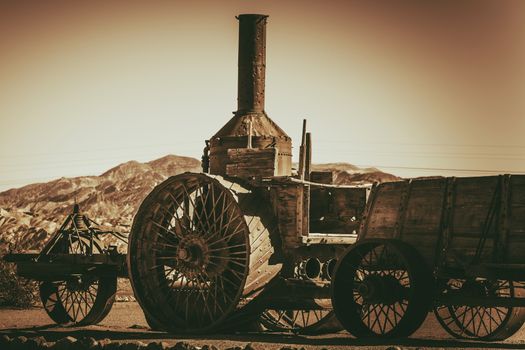 Vintage Rusty Steam Engine Tractor in California, United States. History of Agriculture Equipment. Sepia Color Grading.