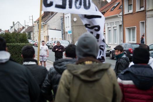FRANCE, Calais: Two Calais inhabitants face a demonstration supporting migrants and refugees on January 23, 2016 in Calais, northern France. Those two men are about to get engaged in a fight with the demonstrators and migrants. 
