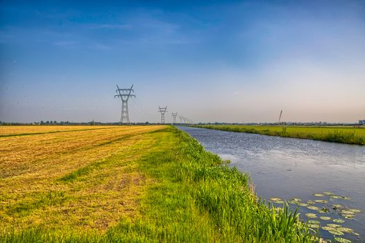 Dutch landscape with a canal and grass fields with mirror reflection in water, Amsterdam, Holland, Netherlands, HDR