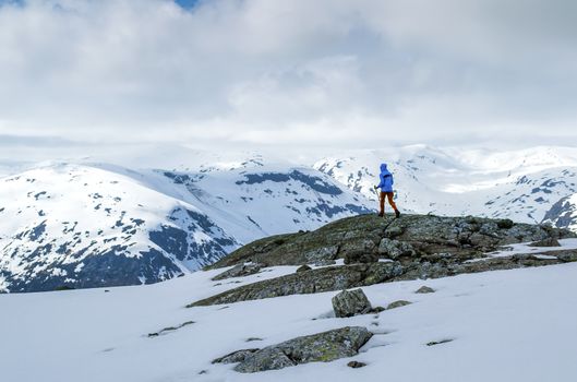 Girl in the mountains. Hiking. The sky covered with clouds. Norway.