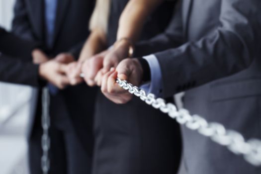 Businessmen pulling chain, teamwork togetherness concept