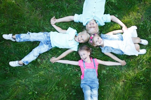 Little friends laying on grass in summer park