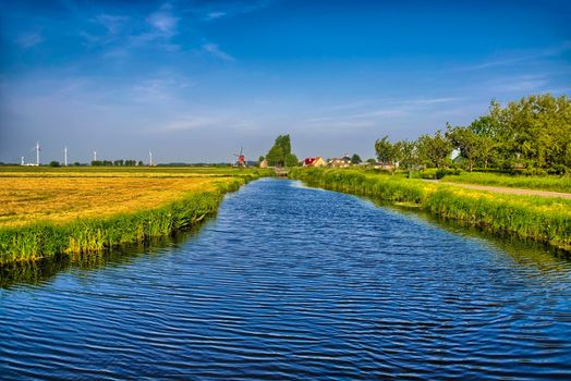 Dutch landscape with a canal and grass fields with mirror reflection in water, Amsterdam, Holland, Netherlands, HDR