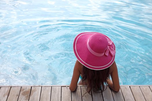 Beautiful woman relaxing at swimming pool at tourist resort