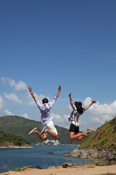 Young happy couple jump and enjoy beautiful sea view on vacation