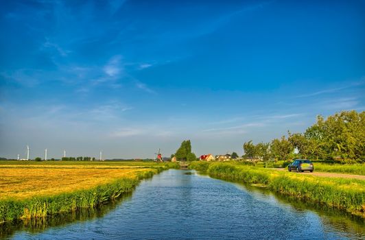 Dutch landscape with a canal and grass fields with mirror reflection in water, Amsterdam, Holland, Netherlands, HDR