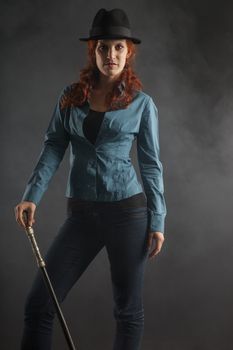 Serious red hair lady with a hat and special walking stick (contrast lightning)