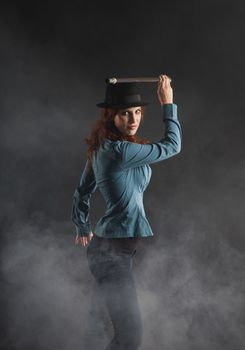 Serious red hair lady with a hat and special walking stick (contrast lightning)