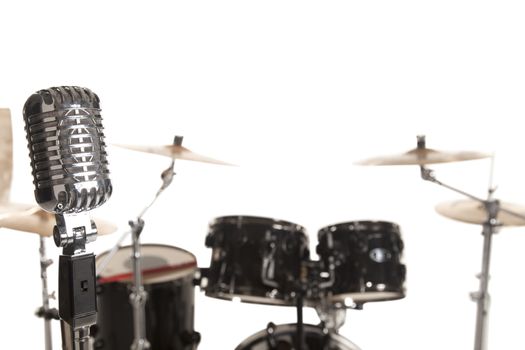 Close-up of microphone in front of Bass Drum Kit over white background
