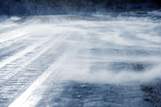 Icy Road with Drifting Snow Closeup. Dangerous Icy Road Conditions.