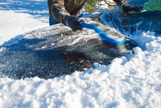 Snow Removal From Car. Men Cleaning Car From the Snow.