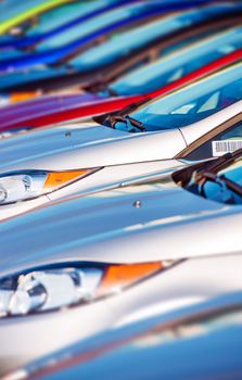 New Cars Stock in Row. Modern Compact Cars Dealership Parking Lot Closeup.