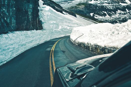 Alpine Road Drive During Spring. Dangerous Snow Piles on Sides of the Mountain Road. High Mountains Road Trip.