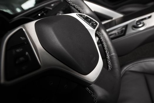 Car Steering Wheel. Driving Concept. Dark Car Interior with Steering Wheel Closeup.