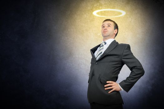 Businessman with nimbus and looking up on grey background