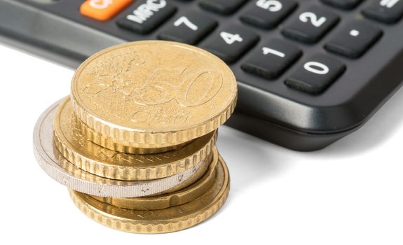 Calculator with stack of coins isolated on white background, closeup