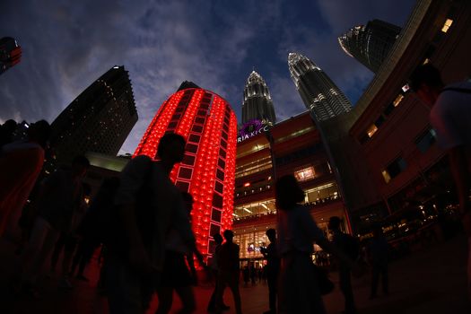 MALAYSIA, Kuala Lumpur: People walk past red lantern decorations ahead of Lunar New Year celebrations at a shopping mall in front of Petronas Twin Towers in Kuala Lumpur on January 25, 2016.