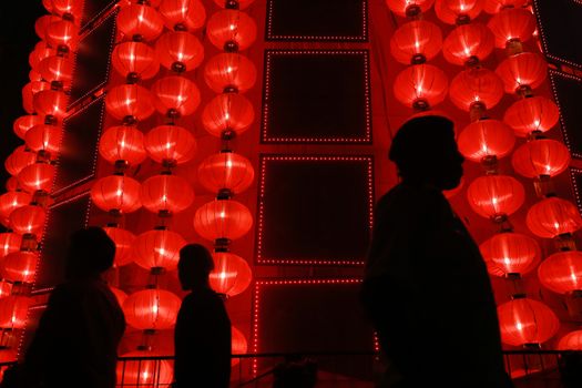MALAYSIA, Kuala Lumpur: People walk past red lantern decorations ahead of Lunar New Year celebrations at a shopping mall in front of Petronas Twin Towers in Kuala Lumpur on January 25, 2016.